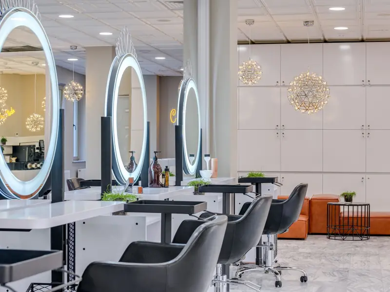 Leather chairs facing round salon mirrors